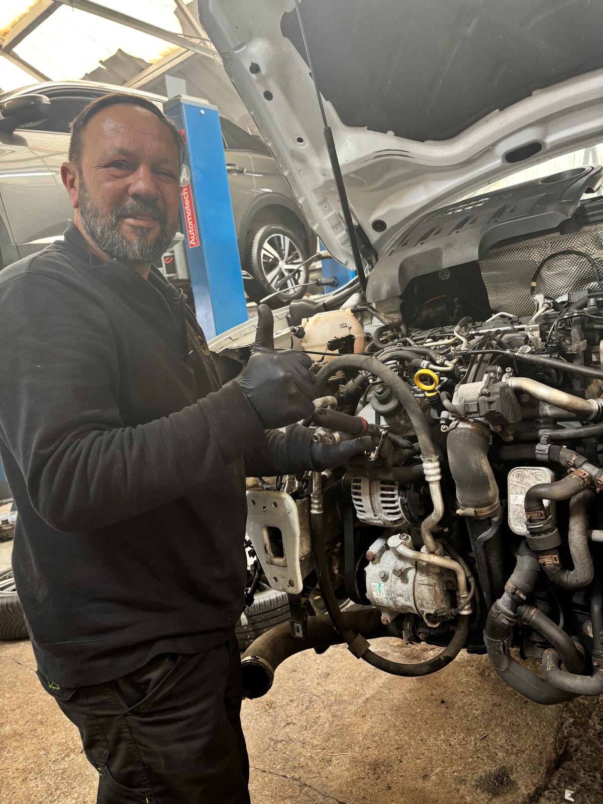 Mechanic Bircan giving thumbs up after engine repair